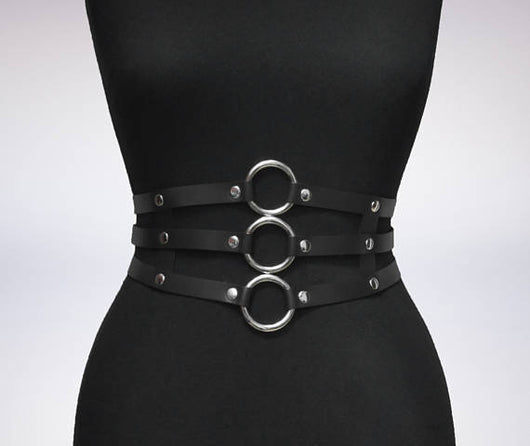 Women's black leather waist belt with three layers, silver-tone metal O-rings, and rivets on a black mannequin. - Image 10