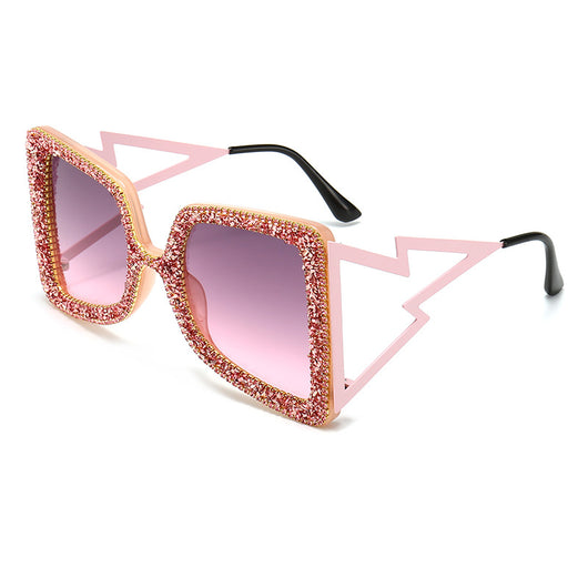 Women's oversized square sunglasses with cream frames, green rhinestones, brown gradient lenses, and lightning bolt temples.