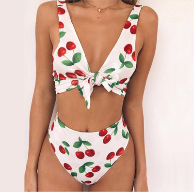White two-piece bikini swimsuit with red cherry print, featuring a tie-front V-neck top and high-waisted bottoms. - Image 15