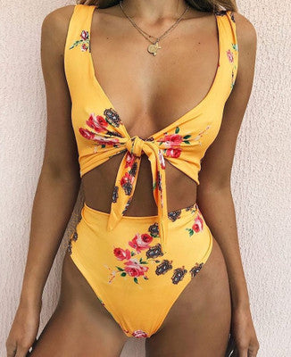 White two-piece bikini swimsuit with red cherry print, featuring a tie-front V-neck top and high-waisted bottoms.