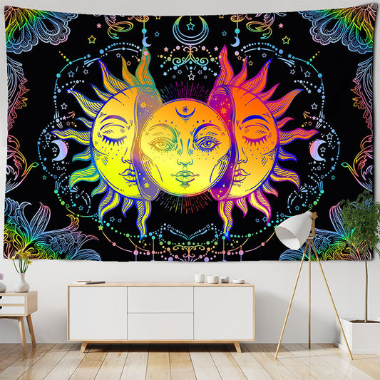 Abstract tapestry with three sun and moon faces in vibrant yellow, orange, and purple hues on a black background.