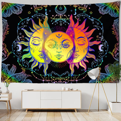 Abstract tapestry with three sun and moon faces in vibrant yellow, orange, and purple hues on a black background.