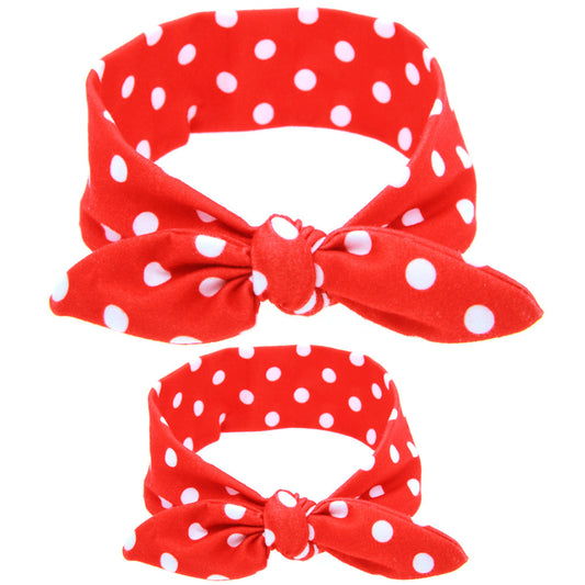 Two blue headbands with white polka dots and knotted bows, one adult-sized and one child-sized, for a matching set.