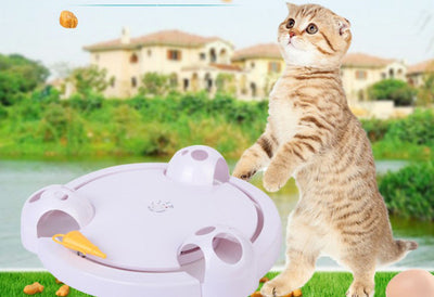 White interactive cat toy with a yellow feather, designed for mouse pouncing, next to a silver tabby cat. - Image 3