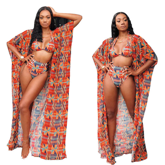Woman wearing a red, orange, and blue geometric print three-piece swimsuit with a high-waisted bikini and long kimono cover-up.