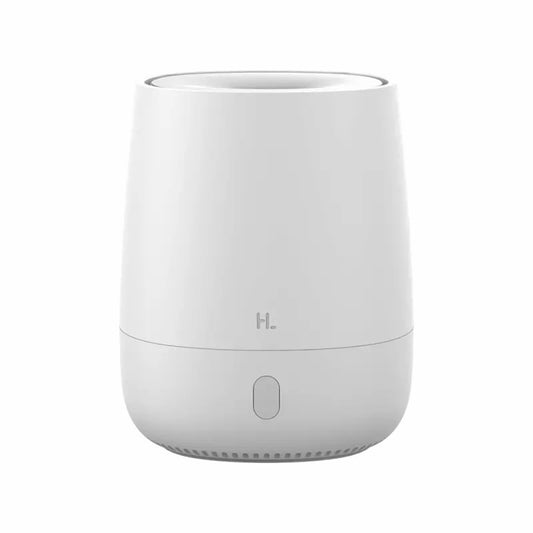 White minimalist aroma diffuser emitting mist, with a single button, on a white nightstand next to a bed.