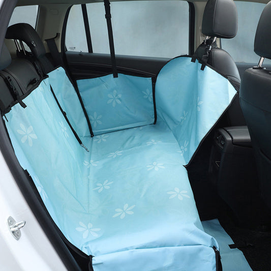 Beige pet car seat cover with a colorful dog pattern, installed in the rear of a car to protect seats.