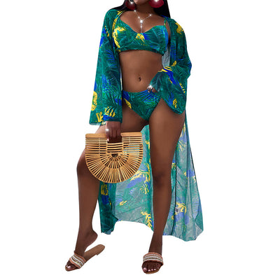Women's three-piece tropical print bikini and kimono cover-up set in orange, green, and pink.