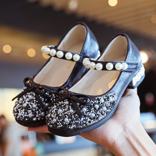 Silver glitter princess shoes for girls with rhinestone and pearl embellishments, a pearl-decorated strap, and a small heel.