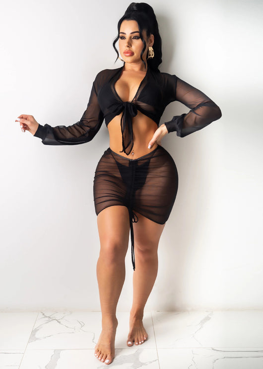 Black sheer mesh long-sleeve tie-front crop top and ruched mini skirt cover-up set over a black bikini. - Image 3