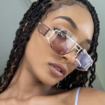 Red oversized rimless sunglasses with a unique geometric design and gold-tone metal temples.