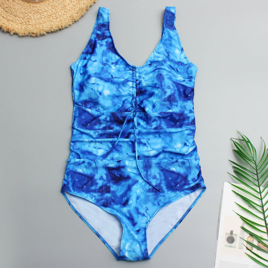 Plus size one-piece swimsuit with blue and white floral digital print, V-neck, and ruched front.