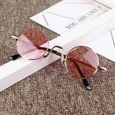 Retro round sunglasses with gold-colored frames and yellow tinted lenses, displayed on a textured surface. - Image 8