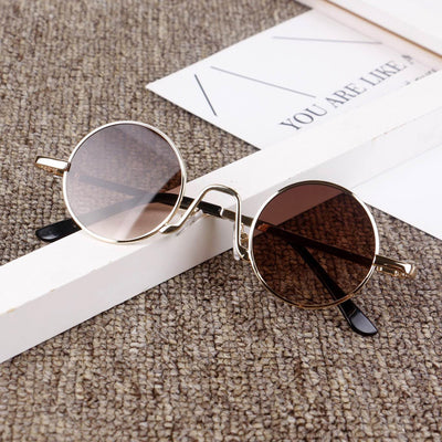 Retro round sunglasses with gold-colored frames and yellow tinted lenses, displayed on a textured surface. - Image 9