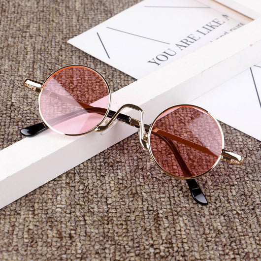 Retro round sunglasses with gold-colored frames and yellow tinted lenses, displayed on a textured surface. - Image 3