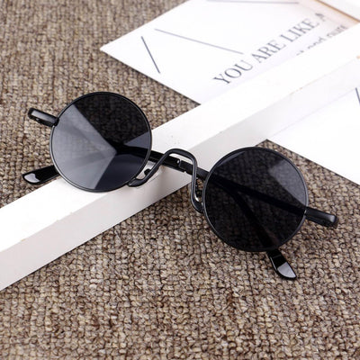 Retro round sunglasses with gold-colored frames and yellow tinted lenses, displayed on a textured surface. - Image 4