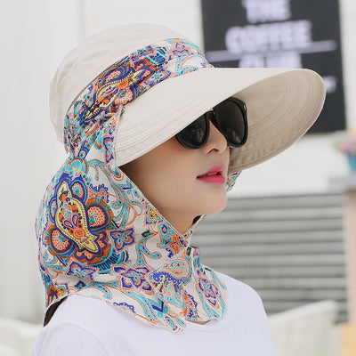 Woman wearing a light yellow wide-brim sun hat with a colorful paisley neck flap and dark sunglasses. - Image 5