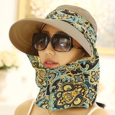 Woman wearing a light yellow wide-brim sun hat with a colorful paisley neck flap and dark sunglasses. - Image 6