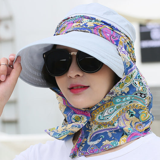 Woman wearing a light yellow wide-brim sun hat with a colorful paisley neck flap and dark sunglasses. - Image 7