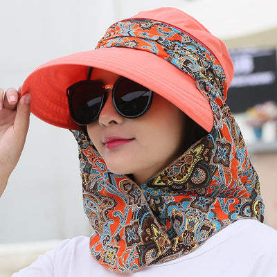 Woman wearing a light yellow wide-brim sun hat with a colorful paisley neck flap and dark sunglasses. - Image 8