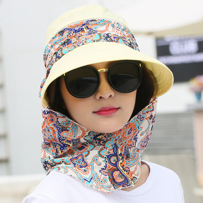 Woman wearing a light yellow wide-brim sun hat with a colorful paisley neck flap and dark sunglasses. - Image 9