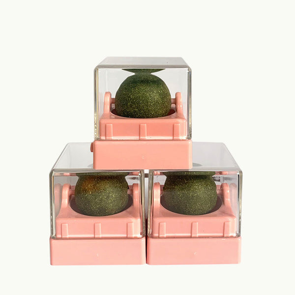 Assortment of rotating catnip balls in pink, green, gray, blue, and purple, each in a clear plastic case.