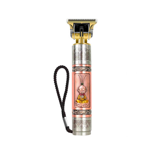 Professional electric hair clipper with gold T-blade, bronze and silver decorative handle, and black wrist strap.