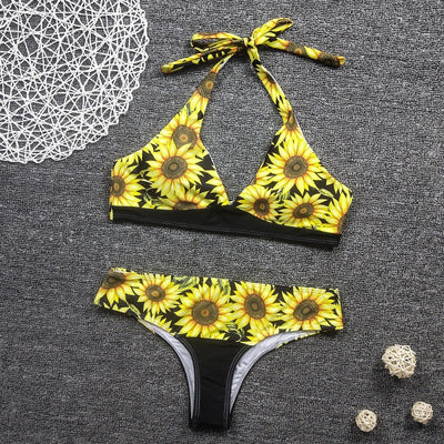 Women's two-piece bikini with a vibrant sunflower print on a black background, featuring a halter-neck top and matching bottom. - Image 6
