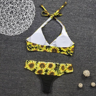 Women's two-piece bikini with a vibrant sunflower print on a black background, featuring a halter-neck top and matching bottom. - Image 7