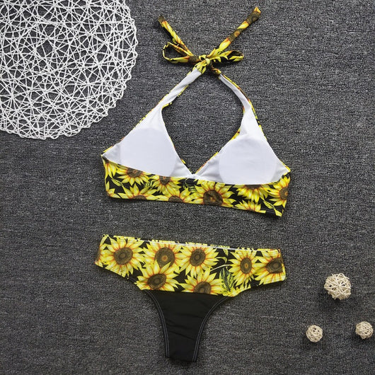 Women's two-piece bikini with a vibrant sunflower print on a black background, featuring a halter-neck top and matching bottom. - Image 4