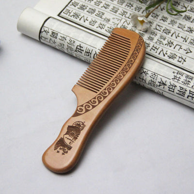 Light brown wooden comb with fine teeth and an ergonomic handle featuring engraved traditional Chinese patterns and a stylized face. - Image 8