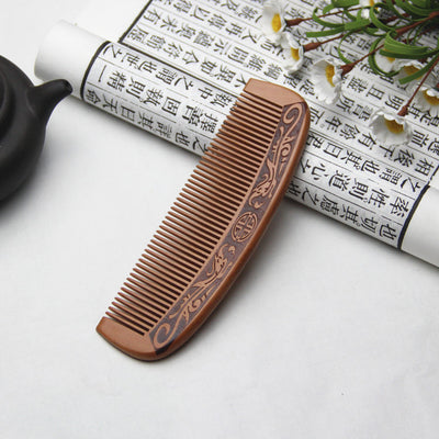 Light brown wooden comb with fine teeth and an ergonomic handle featuring engraved traditional Chinese patterns and a stylized face. - Image 9