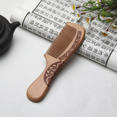 Light brown wooden comb with fine teeth and an ergonomic handle featuring engraved traditional Chinese patterns and a stylized face. - Image 7
