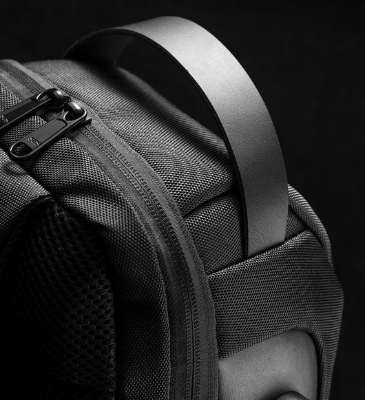 Light grey men's sling bag with a textured canvas finish, single padded shoulder strap, and visible USB charging port. - Image 19