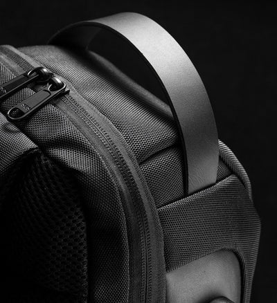 Light grey men's sling bag with a textured canvas finish, single padded shoulder strap, and visible USB charging port. - Image 6