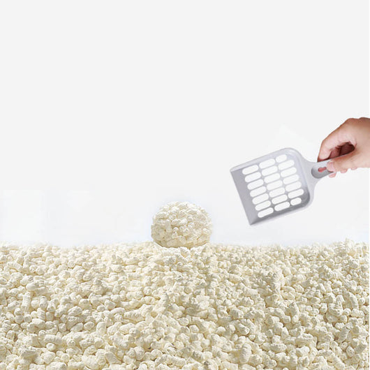 Close-up of a pile of light-colored, irregularly shaped tofu cat litter pellets in a wooden bowl. - Image 6
