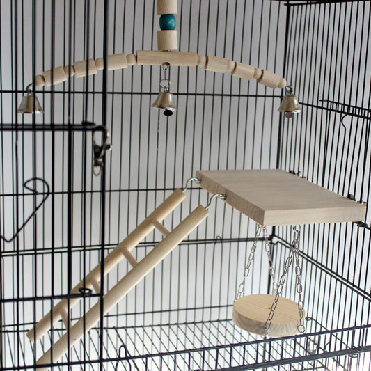Wooden bird chew toy with a curved perch made of beads and cylinders, featuring three silver bells and a blue accent bead, hanging from a metal chain.