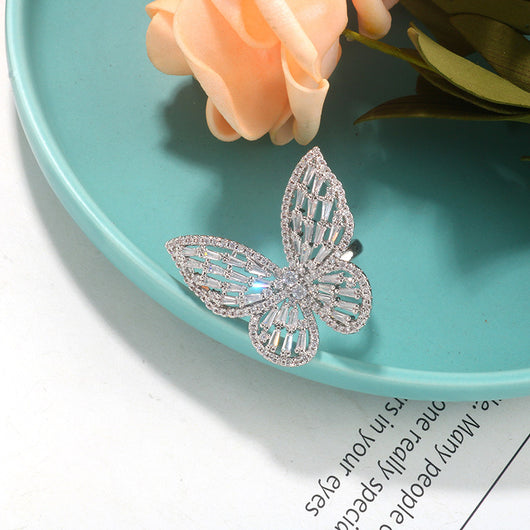 Sparkling silver-tone butterfly ring with clear baguette and round cut stones on a white surface. - Image 3