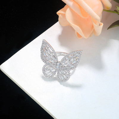 Sparkling silver-tone butterfly ring with clear baguette and round cut stones on a white surface. - Image 4
