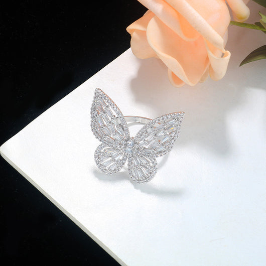 Sparkling silver-tone butterfly ring with clear baguette and round cut stones on a white surface. - Image 4