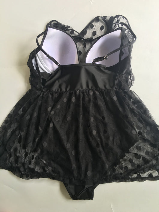 Plus size woman in a black one-piece swimsuit with a sheer mesh top and a short, polka-dot skirt overlay. - Image 12