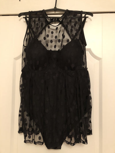 Plus size woman in a black one-piece swimsuit with a sheer mesh top and a short, polka-dot skirt overlay. - Image 9
