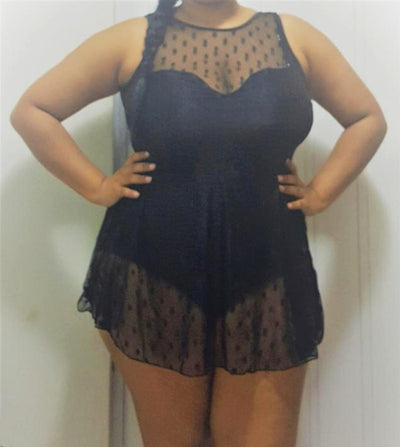 Plus size woman in a black one-piece swimsuit with a sheer mesh top and a short, polka-dot skirt overlay. - Image 3