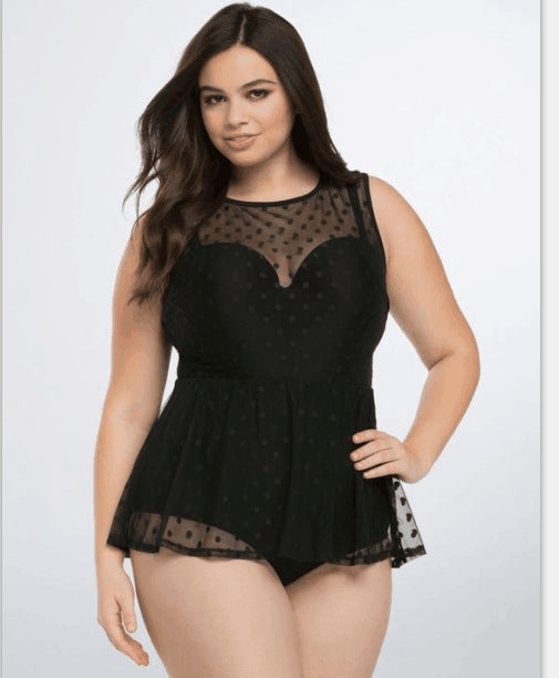 Plus size woman in a black one-piece swimsuit with a sheer mesh top and a short, polka-dot skirt overlay.