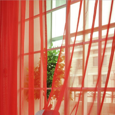 Close-up of a solid red sheer tulle curtain hanging in front of a window, allowing light to filter through. - Image 36