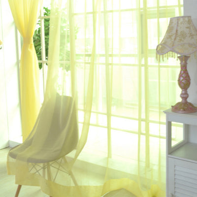 Close-up of a solid red sheer tulle curtain hanging in front of a window, allowing light to filter through. - Image 33