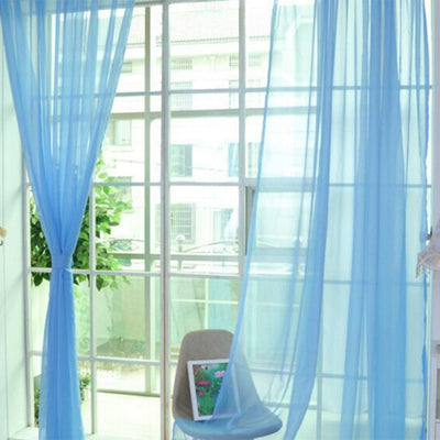 Close-up of a solid red sheer tulle curtain hanging in front of a window, allowing light to filter through. - Image 41