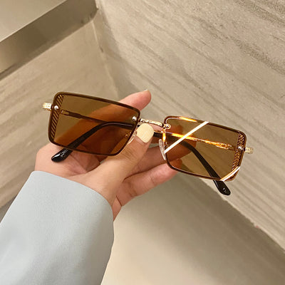 Retro small box red sunglasses with square resin lenses and gold-colored frames, held by a hand. - Image 12