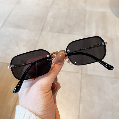 Trendy small frame square sunglasses with brown gradient lenses and gold-tone metal frames, held by a hand. - Image 2
