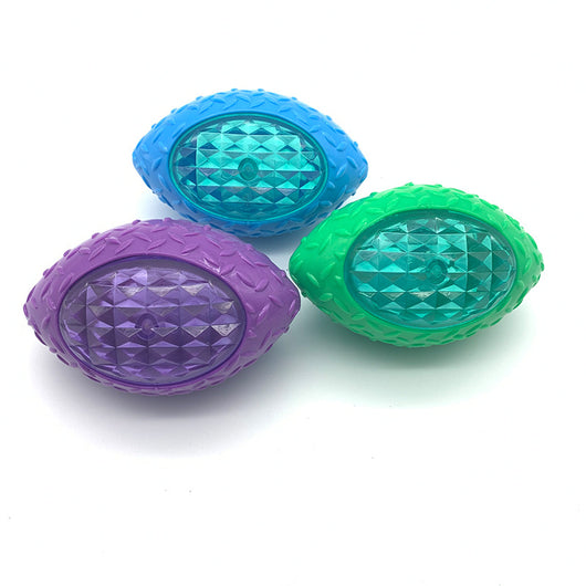 Green rubber pet toy shaped like a rugby ball with a translucent, faceted center for dogs.